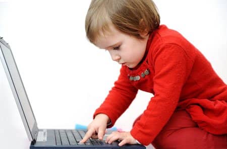 toddler kneeling in front of open laptop pressing buttons on keyboard-genibliss-family online privacy