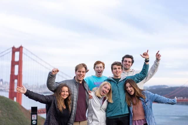 a group of young adult cousins posing outside by the golden gate bridge